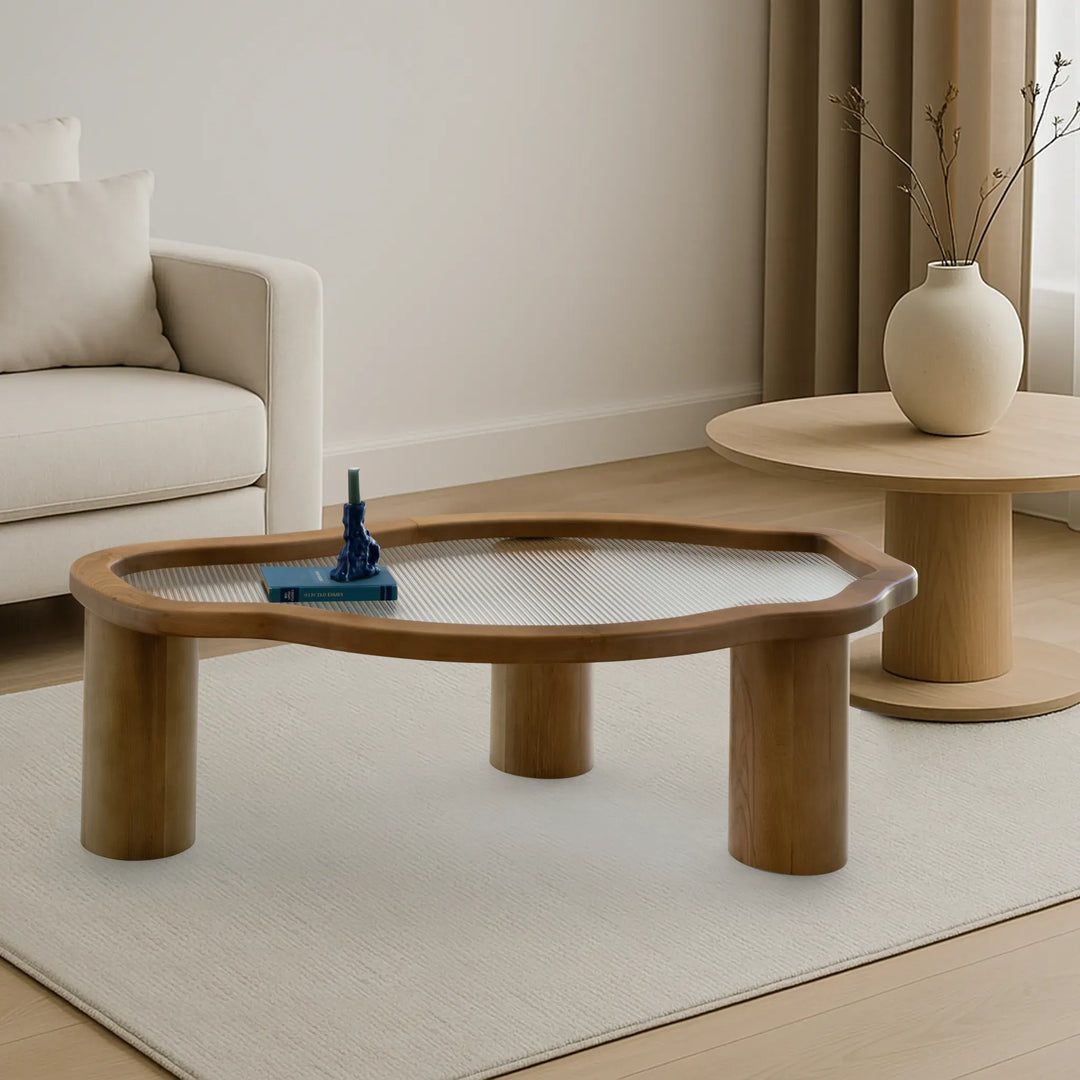 Featuring a glass top and wood base, The Jamie Coffee Table adds sophistication to the lifestyle scene, perfect for modern homes.