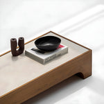 تحميل الصورة إلى عارض المعرض، The Noah Low Coffee Table set against a grey backdrop, highlighting its rich wood grain and marble accents—ideal for modern living rooms.