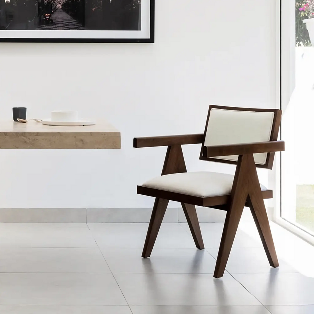 The Pierre wood frame dining chair positioned around a contemporary dining table, perfect for modern homes.