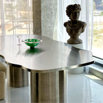 تحميل الصورة إلى عارض المعرض، The Victoria steel dining table in a stylish living space, showcasing its curvy design and stainless steel finish.